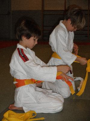 Tristan neemt zijn geel/oranje gordel in ontvangst<br>
Gregory neemt zijn gele gordel in ontvangst.